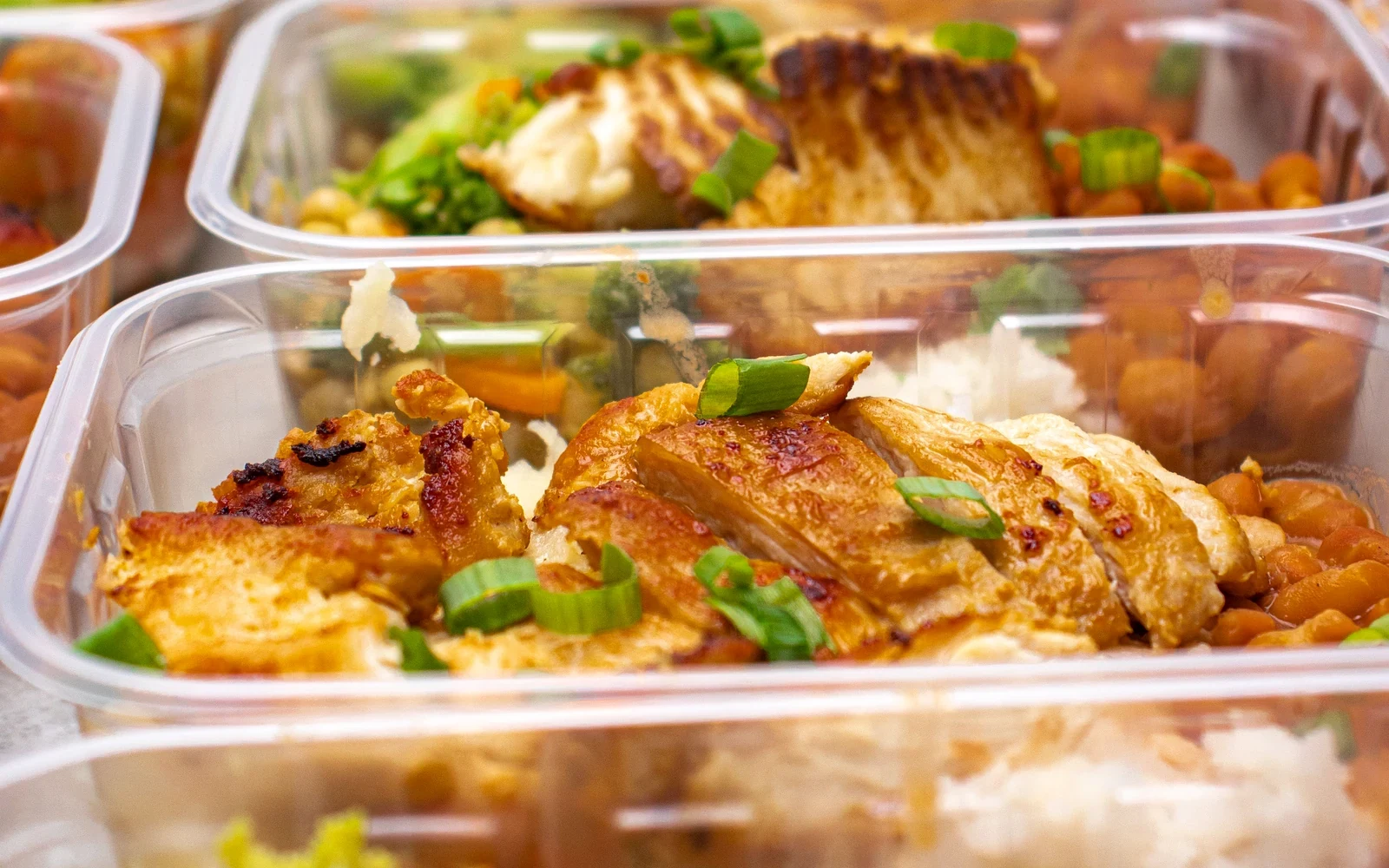Prepared meal containers with chicken, rice and colorful vegetables